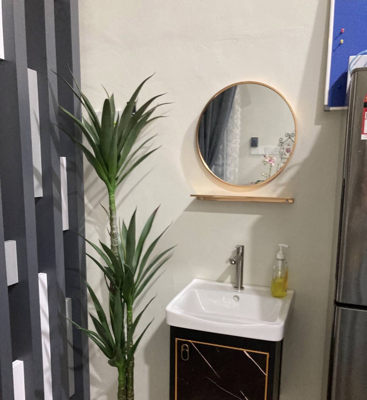 Bathroom vanity with round mirror and marble-pattern cabinet