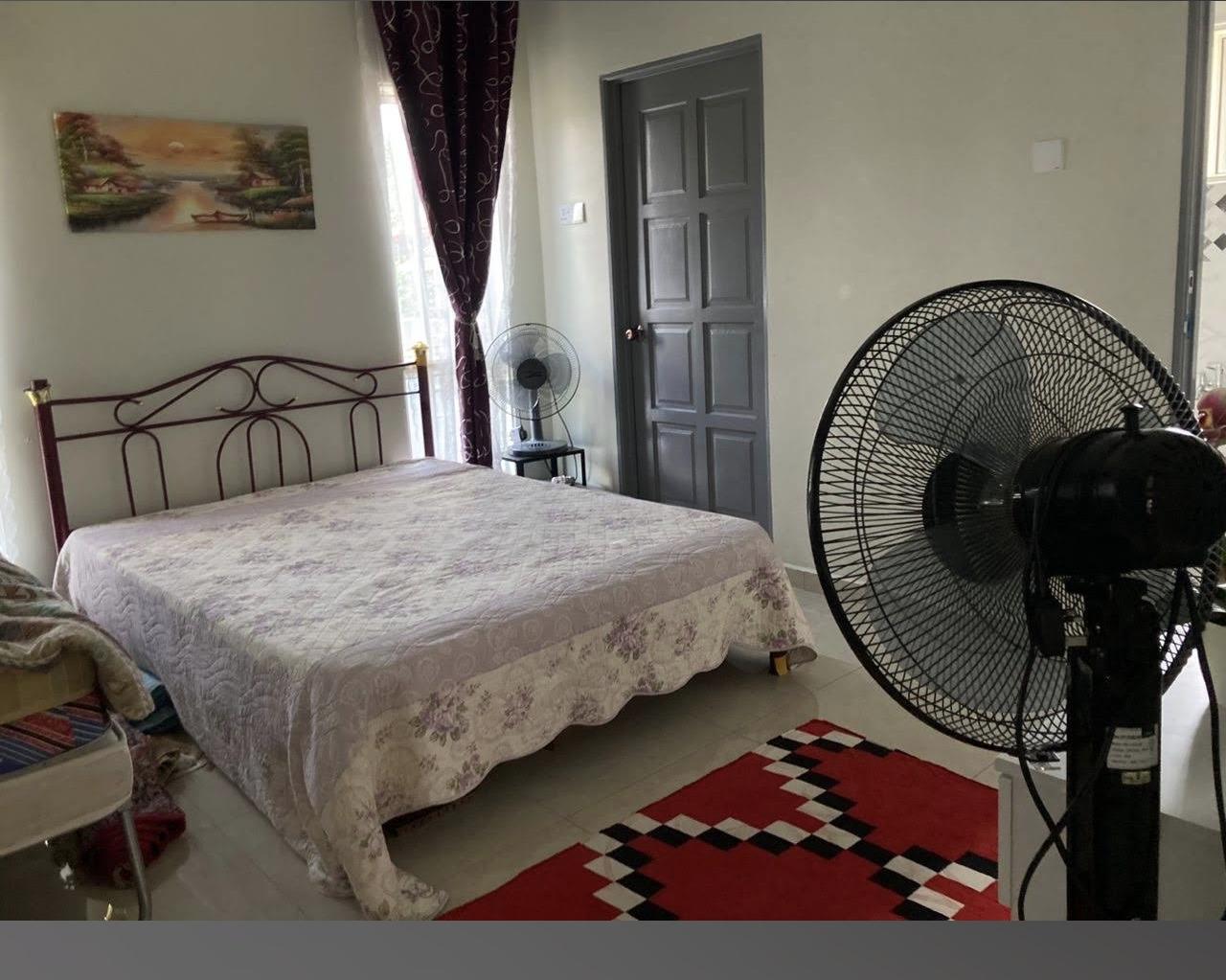 Garden-facing bedroom with iron-frame bed and standing fan